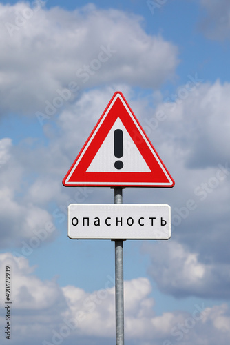 A sign with a exclamation mark warning for a dangerous situation ahead and a smaller sign below with the Russian word for danger on it