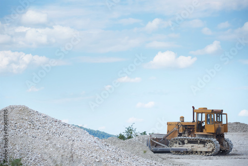 Tractor grader raking gravel in production. Industrial enterprise.