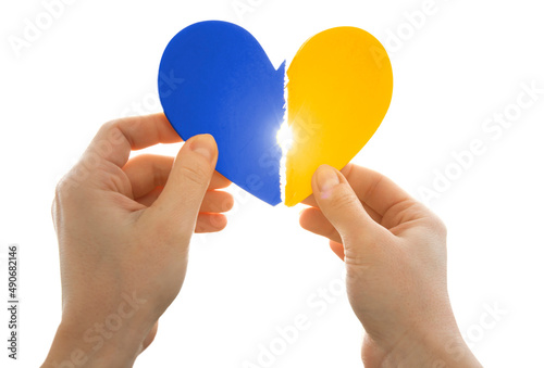 The broken wooden heart in colors of Ukrainian flag in woman s hands