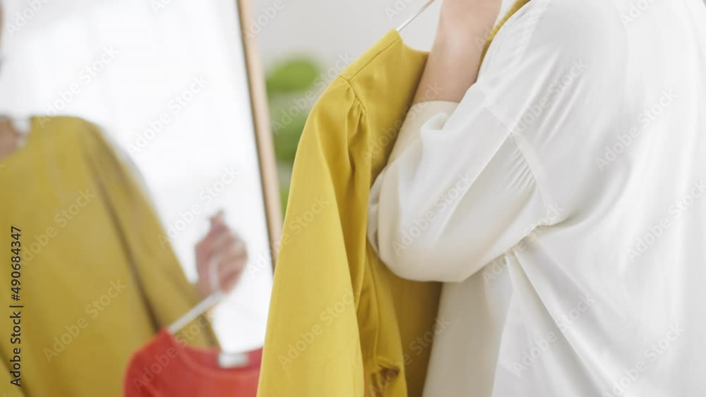 鏡の前で服選びをしている若い女性 ファッションイメージ 鏡の前で服選びをしている若い女性 ファッションイメージ