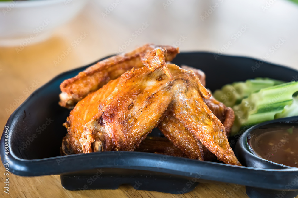 Deep fried chicken wings and green fried herb leaves, selective focus of Thai meal. Deep fried chicken wings and green fried herb leaves, selective focus of Thai meal.