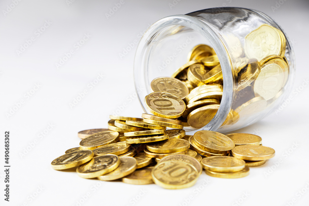 Gold coins in a glass jar isolated on a white background. Money in a pot.Copy space. Place for text. Gold coins in a glass jar isolated on a white background. Money in a pot.Copy space. Place for text.