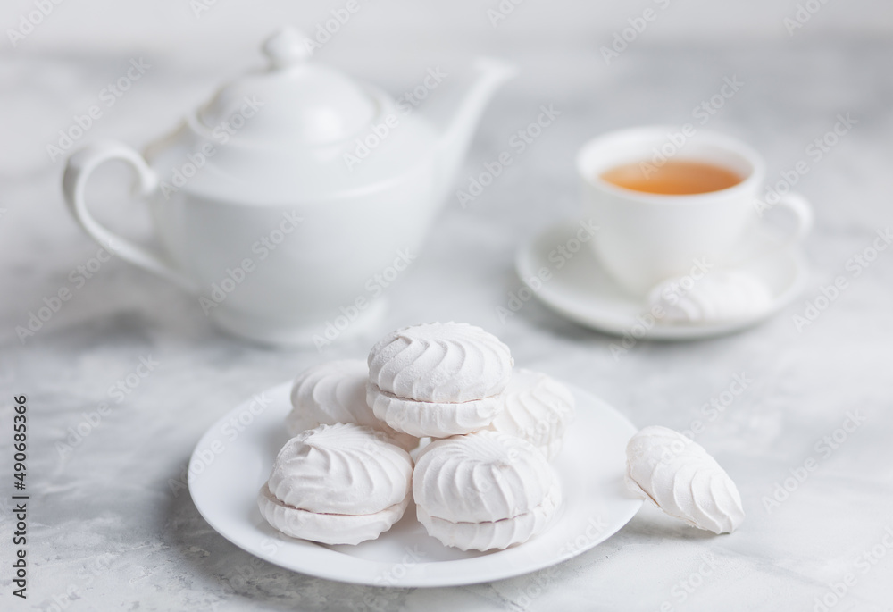 A stack of white marshmallows on a concrete background. The concept of minimalism in vegan sweets. Selective focus. A stack of white marshmallows on a concrete background. The concept of minimalism in vegan sweets. Selective focus.
