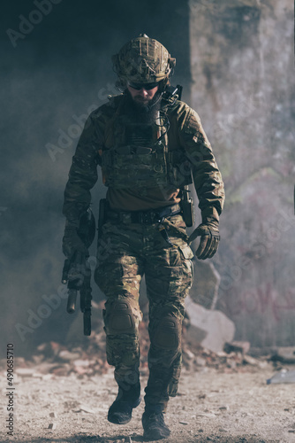 Картината върху платно A bearded soldier in a special forces uniform walks through an abandoned building after a successful mission