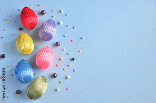 homemade easter eggs from satin ribbons on a blue background layout with space for text