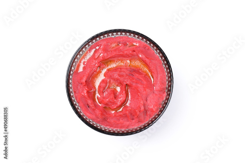 Bowl of beet hummus isolated on white background