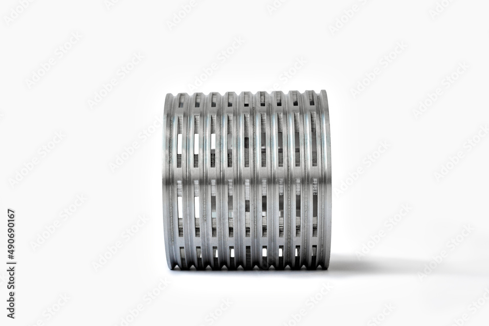 light aluminum part of a cylindrical shape with slots, grooves and round holes on a white background light aluminum part of a cylindrical shape with slots, grooves and round holes on a white background