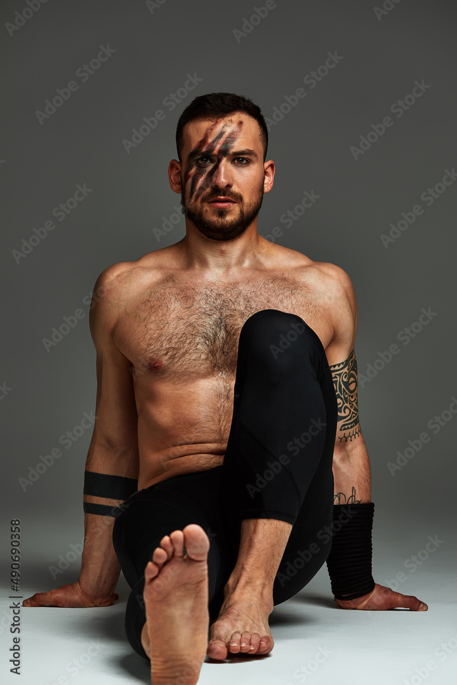 Animal instinct fitness instructor sportsman showing his incredible flexibility with an animal flow move in studio against a gray background Animal instinct fitness instructor sportsman showing his incredible flexibility with an animal flow move in studio against a gray background