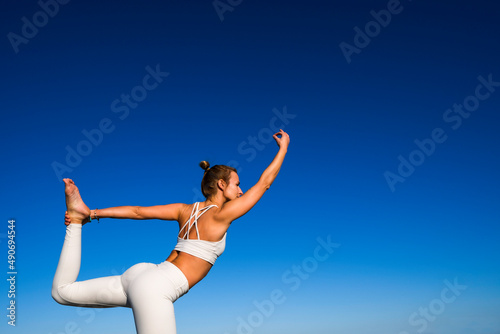girl doing yoga with blue sky background