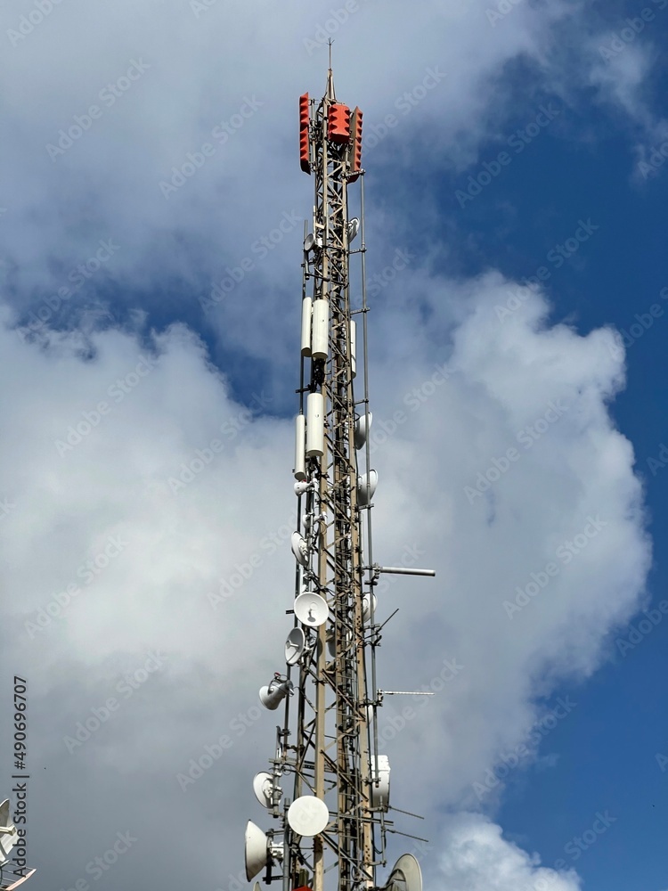 Telecommunication and mobile network infrastructure with two cell site towers side by side, housing antennas and Remote Radio Head, RRH, for greater coverage