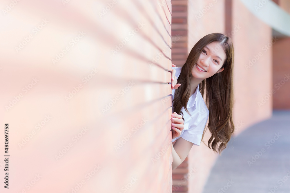 Portrait of an adult Thai student in university student uniform. Asian beautiful girl standing smiling happily at university Portrait of an adult Thai student in university student uniform. Asian beautiful girl standing smiling happily at university