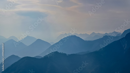 Scenic view on the alpine mountain chains of the Karawanks in Carinthia, Austria. Peaks are shrouded in morning fog. Mystical vibes. Clear and sunny day. Serenity. View from Ferlacher Spitze, Alps © Chris