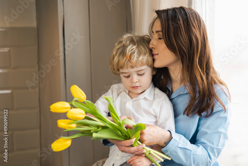 Little boy gave flowers to his mother. .Woman loves her son. Mother's day concept
