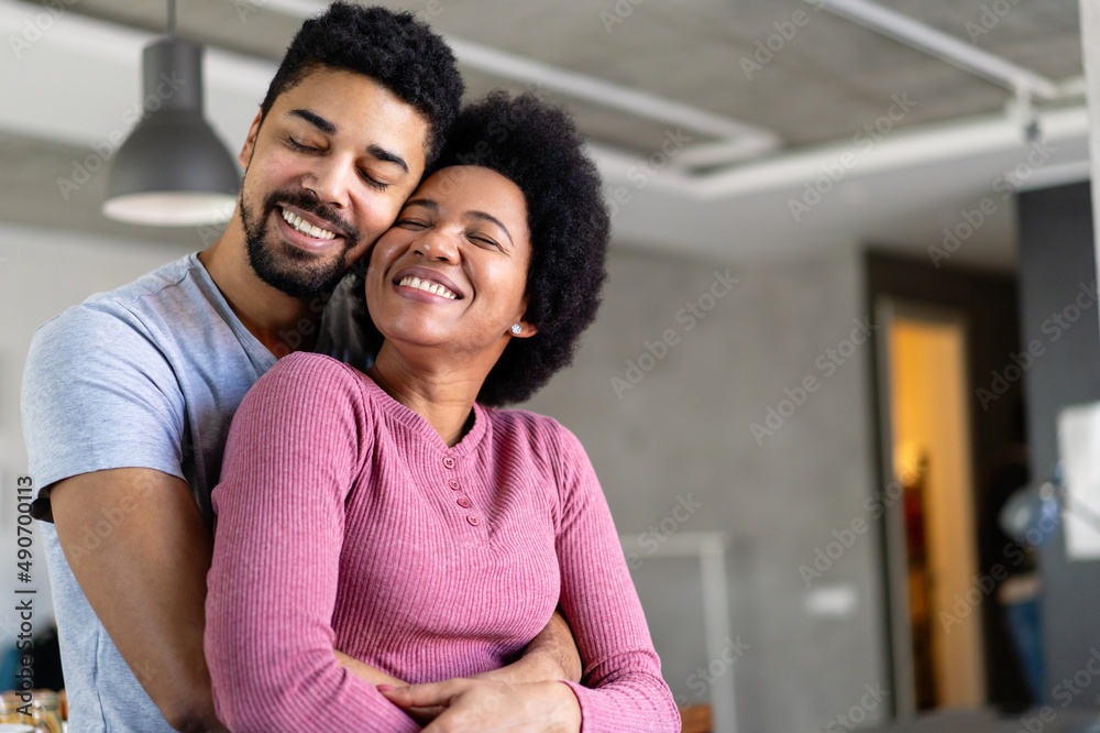 Fototapeta premium Portrait of happy smiling black couple in love having fun and hugging together