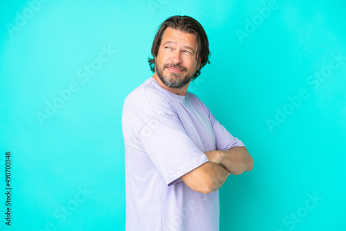 Senior dutch man isolated on blue background with arms crossed and happy © luismolinero