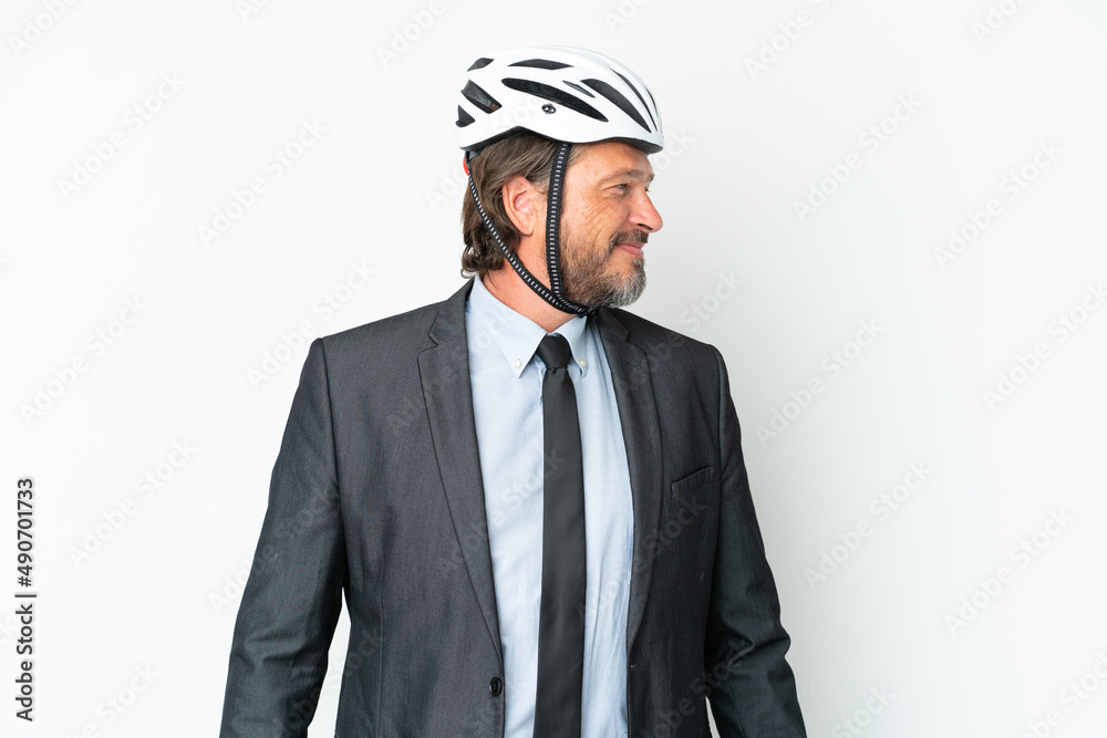 Fototapeta premium Business senior man with a bike helmet isolated on white background looking side