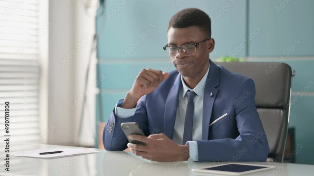 Upset Young African Businessman Reacting to Loss on Smartphone Upset Young African Businessman Reacting to Loss on Smartphone