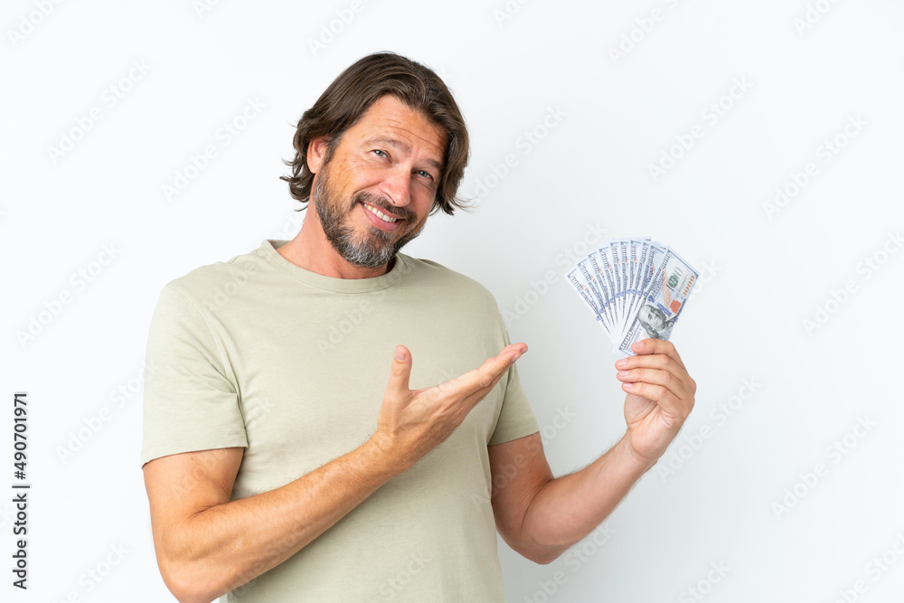 Senior dutch man taking a lot of money isolated on white background extending hands to the side for inviting to come Senior dutch man taking a lot of money isolated on white background extending hands to the side for inviting to come