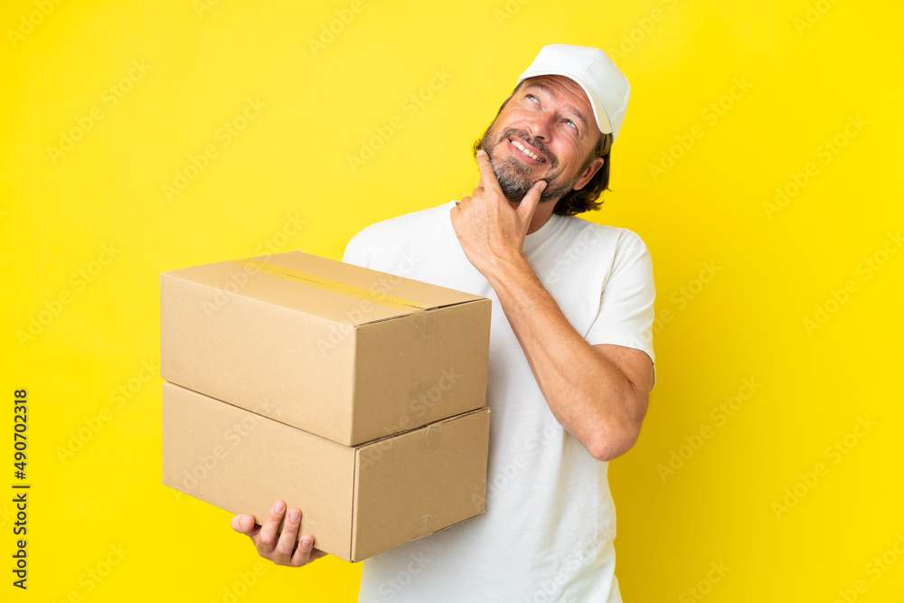 Delivery senior dutch man isolated on yellow background happy and smiling Delivery senior dutch man isolated on yellow background happy and smiling