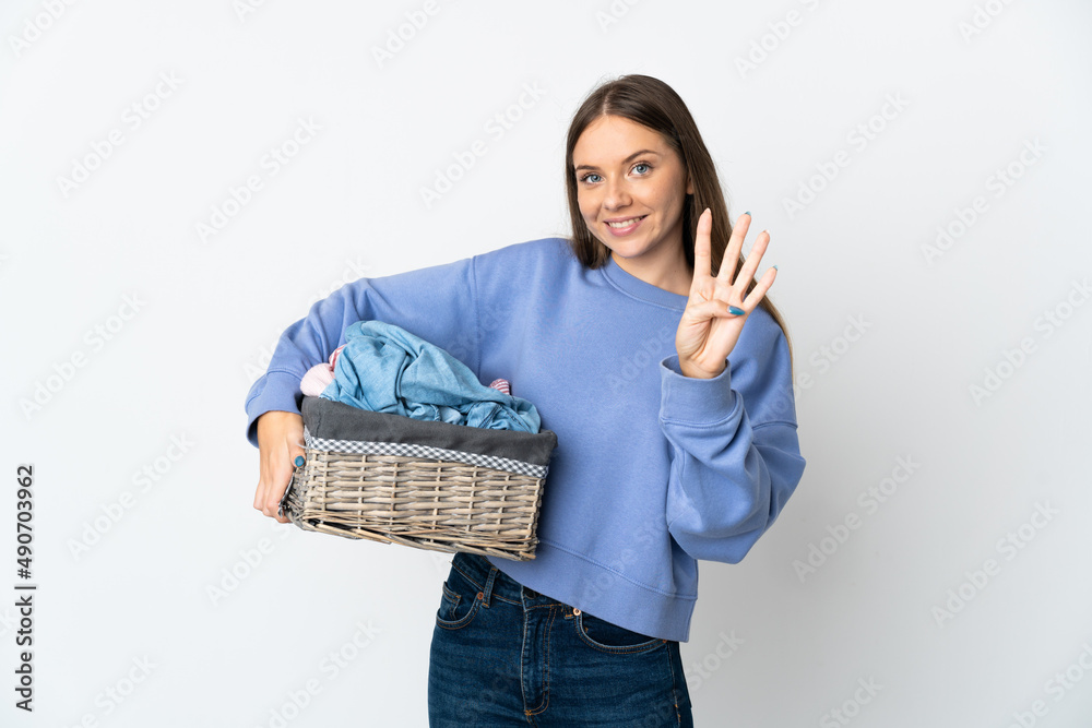 Young Lithuanian woman holding a clothes basket isolated on white background happy and counting four with fingers