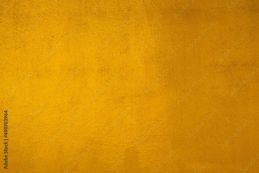 Fototapeta premium Gold wall texture background. Yellow shiny gold paint on concrete wall surface
