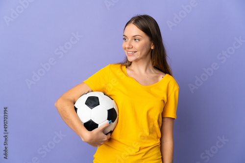 Young Lithuanian football player woman isolated on purple background looking to the side and smiling © luismolinero