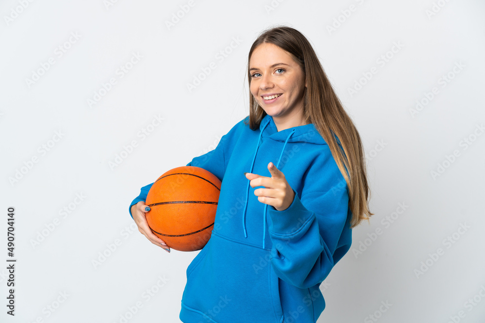 Young Lithuanian woman isolated on white background playing basketball and pointing to the front