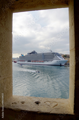 Mega modern MSC cruiseship or cruise ship liner in port of Valletta, Malta island with panoramic scenic view of historic old town, city walls and fortress skyline on summer day during Med cruising photo