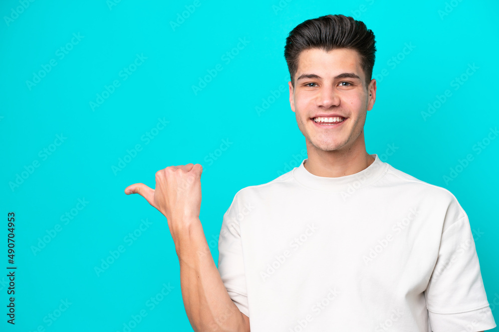 Young handsome caucasian man isolated on blue bakcground pointing to the side to present a product Young handsome caucasian man isolated on blue bakcground pointing to the side to present a product