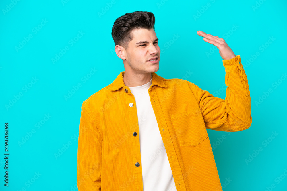 Young handsome caucasian man isolated on blue bakcground with tired and sick expression Young handsome caucasian man isolated on blue bakcground with tired and sick expression