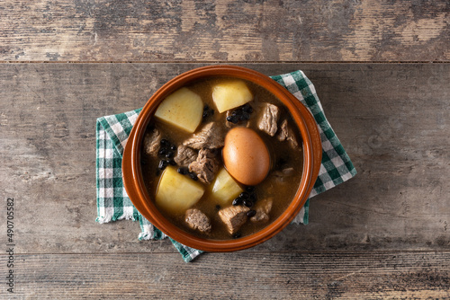 Traditional Jewish cholent in bowl on wooden table	 photo