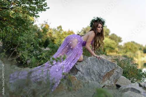 Картината върху платно Mavka water nymph naiad near the water in nature in the forest on the river bank