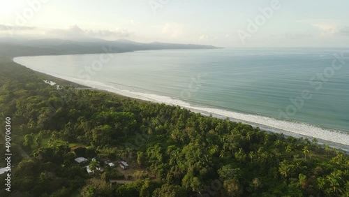 Aerial shot of a beautiful long beach in costa rica. Sunny day close to the pacific ocean and the tropical forest photo