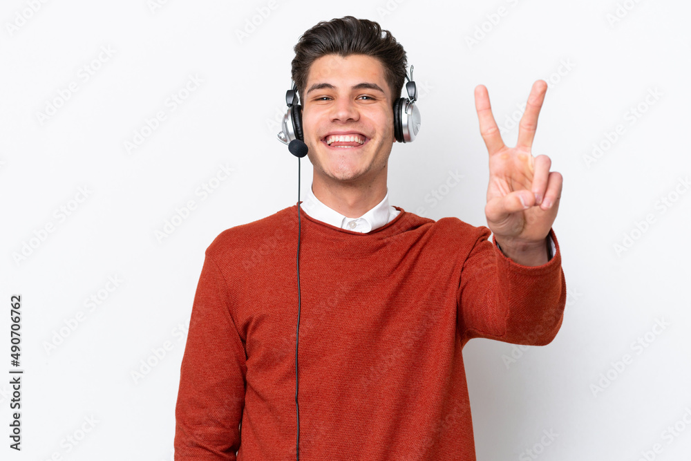 Telemarketer caucasian man working with a headset isolated on white background smiling and showing victory sign Telemarketer caucasian man working with a headset isolated on white background smiling and showing victory sign