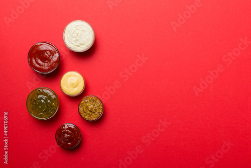 Different types of sauces in bowls on a colored Board . Top view. various sauces copy space
