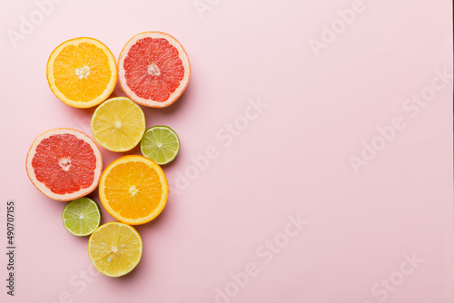 Fruit background. Colorful fresh fruits on colored table. Orange, lemon, grapefruit Space for text healthy concept. Flat lay, top view, copy space