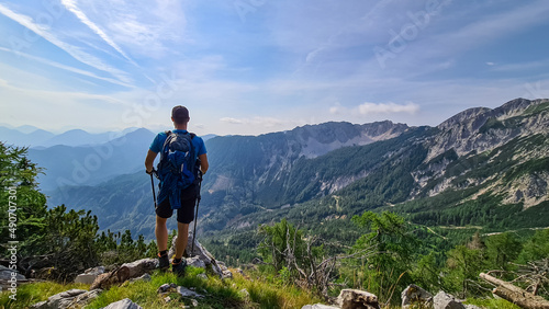 Man admiring the scenic view near  Mittagskogel on the mountain peaks in the Karawanks, Carinthia, Austria. Borders between Austria, Slovenia, Italy. Julian Alps, Triglav National Park. Mystical hills photo