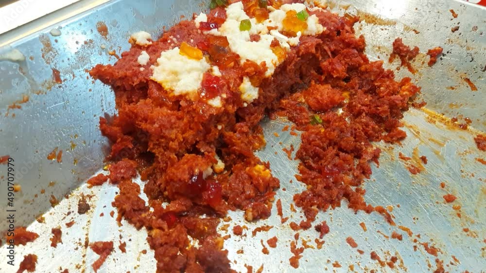 Gajar ka halwa is a carrot based sweet dessert pudding from India. Garnished with Cashew almond nut and jelly. Indian sweet food gajar ka halwa cooking in the pan in the kitchen - Carrot Halwa