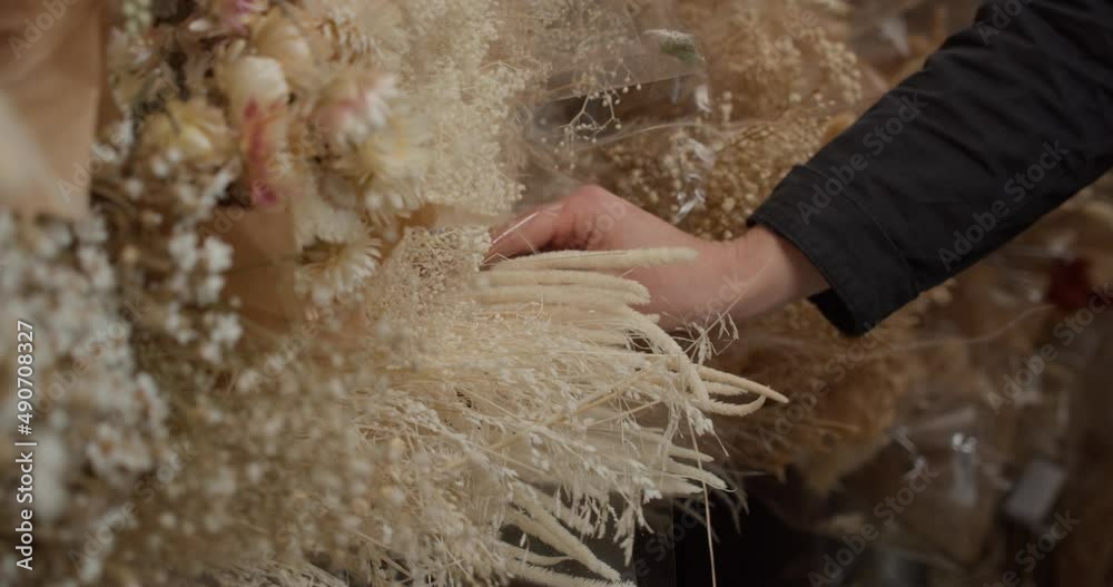 Girl Inserting Single Stem Of Dry Bunny Tail On Bunches Of Dried