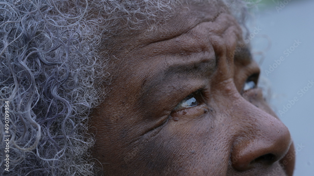 An African older woman looking up at sky with HOPE and FAITH macro eyes face closeup