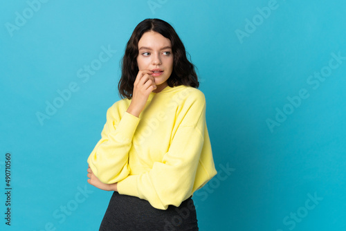 Teenager Ukrainian girl isolated on blue background nervous and scared © luismolinero
