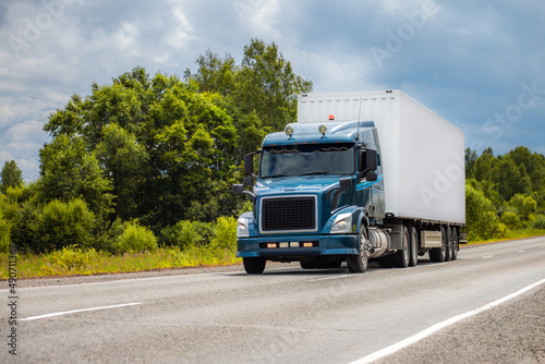 Blue truck on a road in summer