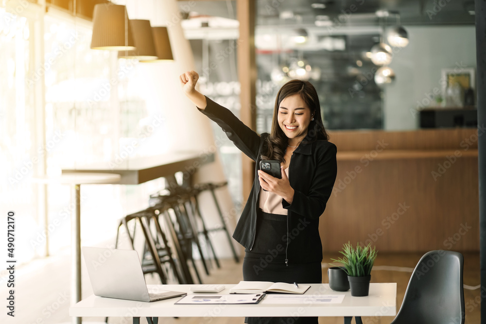 Asian woman smile and looking at smartphone standing feeling happy and surprise. Asian woman smile and looking at smartphone standing feeling happy and surprise.