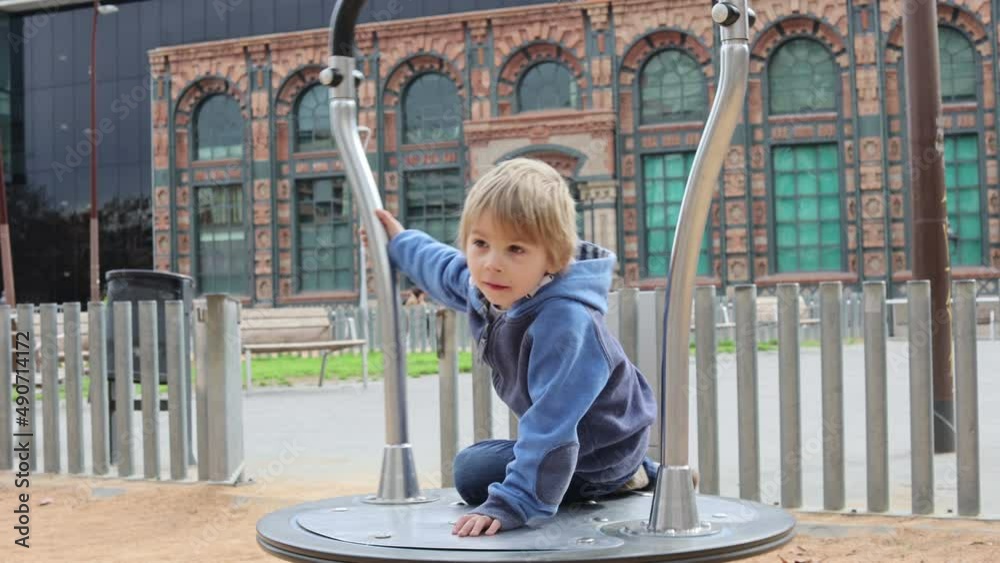 Cute little child, playing on a playground in Barcelona city, family travel with kids in Spain Cute little child, playing on a playground in Barcelona city, family travel with kids in Spain
