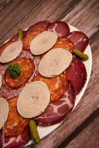 Food tray with delicious salami, pieces of sliced ham, sausage, Deli meats, Pickles, Hight quality photo