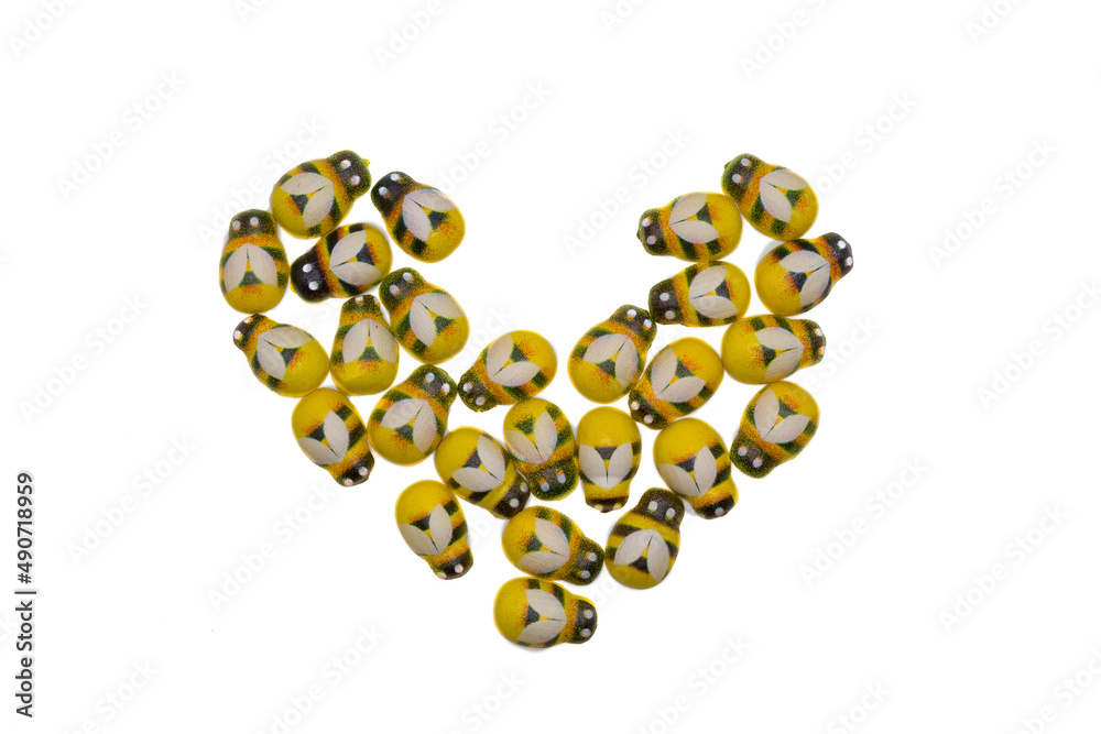 Wooden fittings bright insects yellow bees on a white background in the form of a heart. Wooden fittings bright insects yellow bees on a white background in the form of a heart.