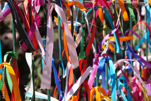 Close up of colourful strings tied to a fence.  The background is intentionally out of focus or blurred. photo