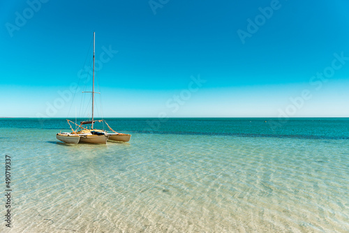 Tropical landscape with yellow sailboat and crystal clear waters of Indian Ocean. At the shore of Monkey Mia beach, summer holidays, seascape