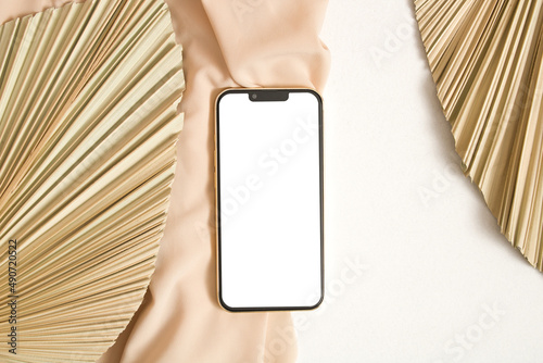 Phone mockup white screen with dry grass palm leaf
