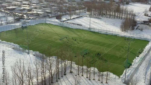 Drone aerial of a soccer team practicing in winter with snow on the ground. photo